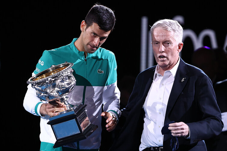 Craig Tiley stands behind Novak Djokovic