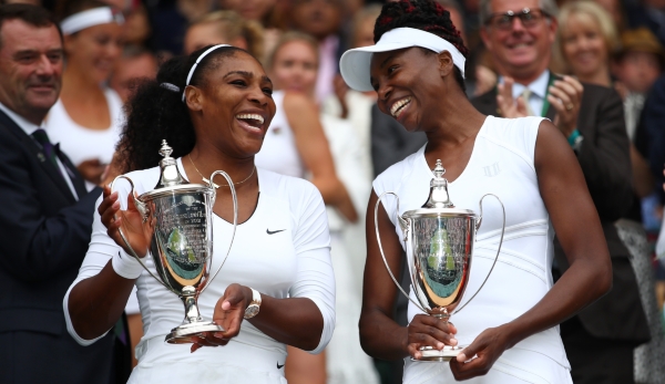 LONDON, ENGLAND - JULY 09: Venus Williams of The United States and Serena Williams of The United States hold their trophies following victory in the Ladies Doubles Final against Timea Babos of Hungary and Yaroslava Shvedova of Kazakhstan on day twel...