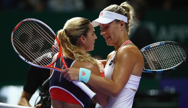 SINGAPORE - OCTOBER 23: Angelique Kerber (R) of Germany celebrates victory in her singles match against Dominika Cibulkova of Slovakia during day 1 of the BNP Paribas WTA Finals Singapore at Singapore Sports Hub on October 23, 2016 in Singapore. (P...